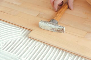 carpenter_picking_up_hammer_on_wood_floor.jpg